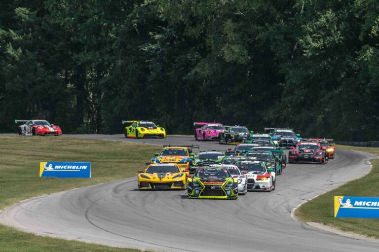 IMSA WeatherTech Sportscar Series race cars racing on Virginia International Raceway going through turns 3-5 with 2 Michelin signs in the grass