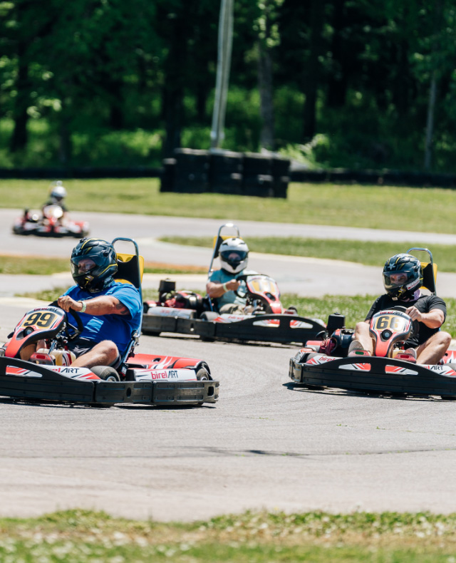 4 people in go karts on the VIR Kart Track racing through turns