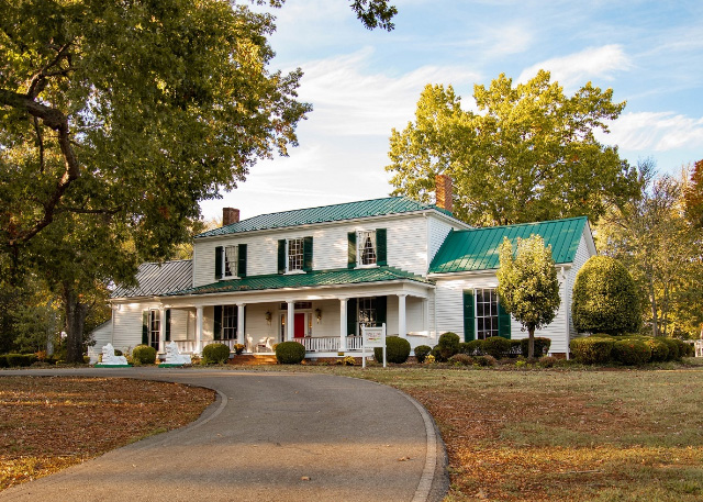 The front of the Oak Tree Tavern - a white house with green roof and trees