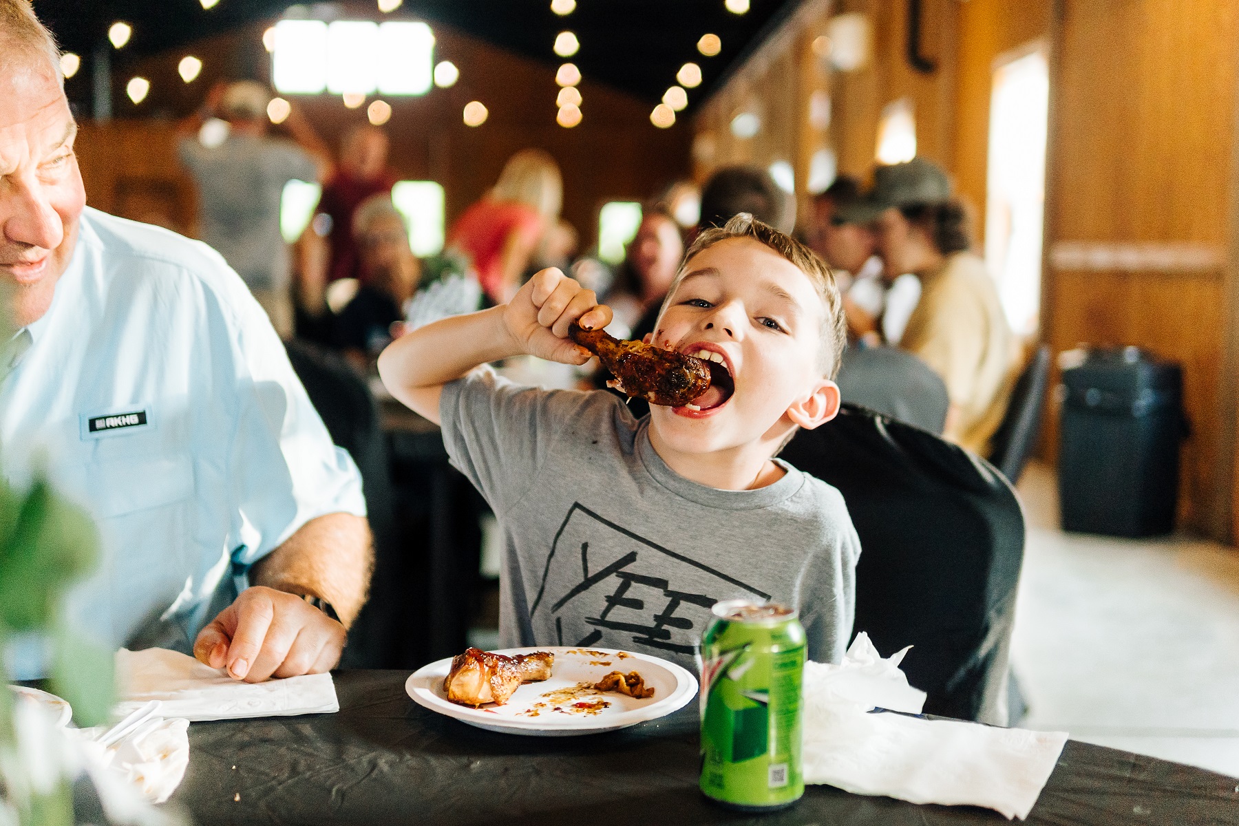 a boy eating chicken leg in the Gallery at VIR