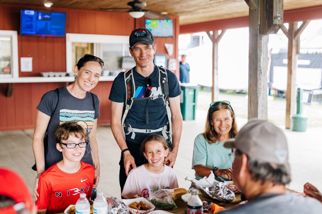 People at a picnic table at the Pagoda eating food and smiling