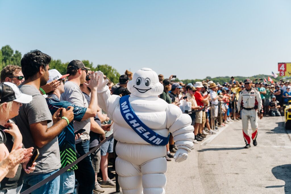 Michelin Man high fives fans during grid walk IMSA 2024 reduced